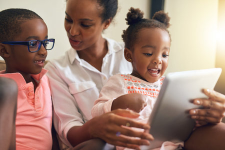 You can have a turn next. an affectionate young family using a tablet together at home.