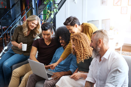 Creating awesome designs. a group of designers working together on a laptop in an office.の写真素材