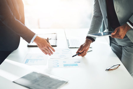 Paperwork is their speciality. two unrecognizable businessmen discussing paperwork at the table in the boardroom.の写真素材