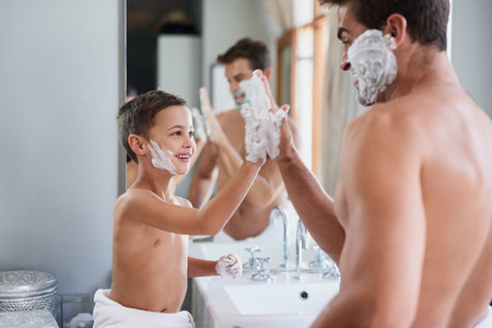 Attaboy. a handsome young man teaching his son how to shave in the bathroom.の写真素材
