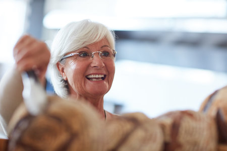 She bakes the best because her customers deserve the best. a happy senior woman working in a bakery.