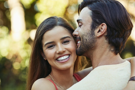 Love starts at home. Portrait of an affectionate young couple sharing a kiss outside.の写真素材
