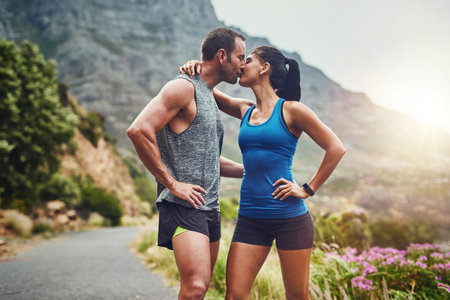 The kiss of rejuvenation. a young attractive couple training for a marathon outdoors.