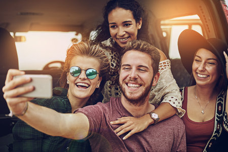 Photo opportunities are frequent when theyre together. a group of friends taking a selfie while on a...