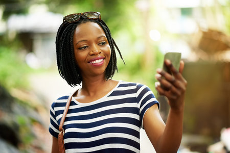Selfie time overseas. a smiling young woman taking a selfie while standing outside in Thailand.