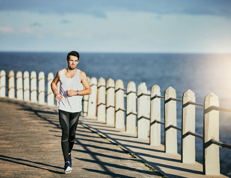 Break your boundaries. a sporty young man out for a run.の写真素材