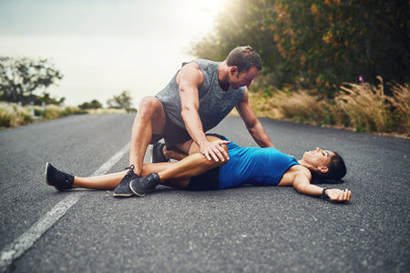 The proper way to stretch. a young attractive couple training for a marathon outdoors.