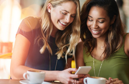 Lets invite all the girls here. girlfriends sharing something on a cellphone while sitting in a...