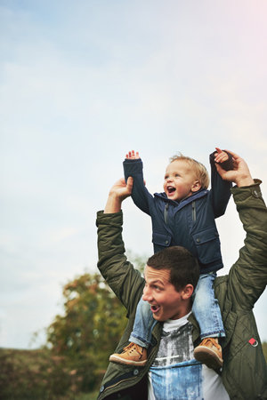 Put your hands up if youre having fun. a father bonding with his son outside.