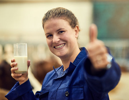 Nothing fresher. Portrait of a happy farmer giving a thumbs up sign while enjoying a glass of fresh milk.の写真素材