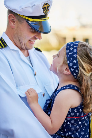 Forever daddys little girl. a father in a navy uniform bonding with his little girl on the dock.の写真素材
