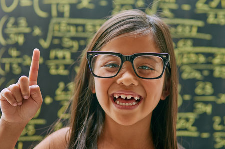 Ive figured it out. Portrait of a little girl posing against a blackboard with maths equations on.の写真素材