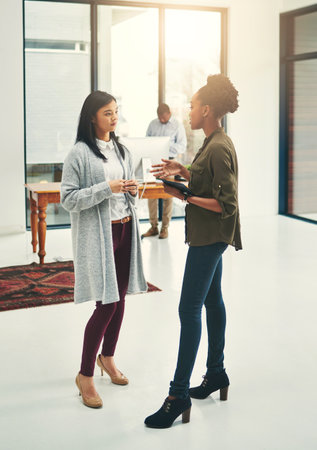Working on a plan of action together. young creatives having a discussion in a modern office.の写真素材