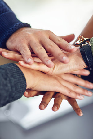United in the name of business. Closeup shot of a diverse team of colleagues joining their hands together in unity.の写真素材