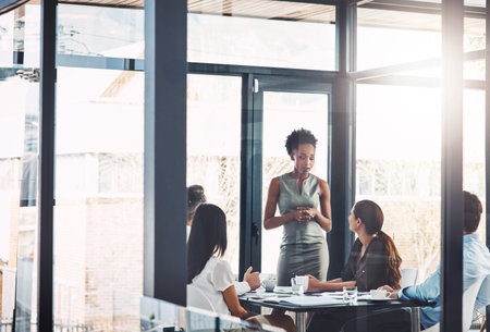 Working closely to get ahead. a businesswoman giving a presentation to her colleagues in a boardroom.の写真素材
