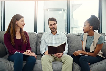 Working on some fresh ideas. a group of colleagues having a discussion in an office.の写真素材