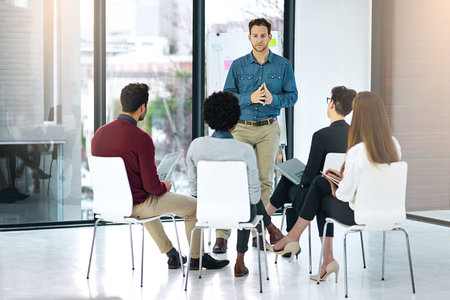 Adding clarity to his ideas. a businessman giving a presentation to his colleagues in a modern...