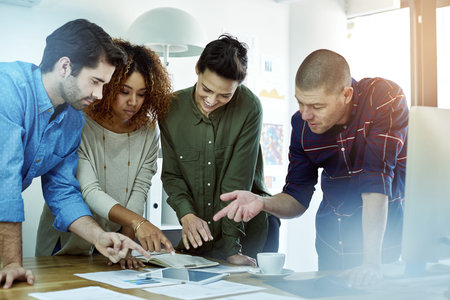 Successful teams are comprised of successful team players. a group of coworkers discussing something...