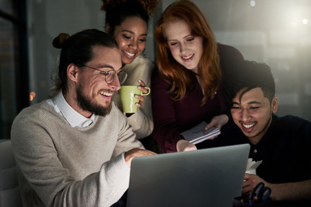 Designing is what makes them happy. a group of young designers working late in the office.の写真素材