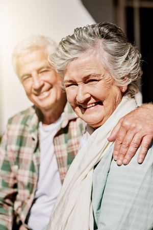 Hes my hubby and he makes me happy. a happy senior couple relaxing together outdoors.の写真素材