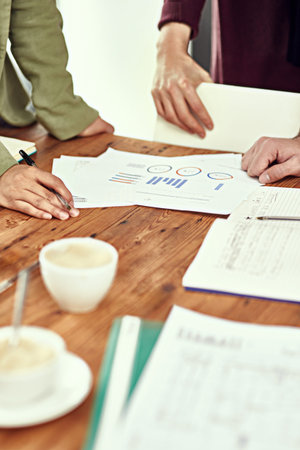Analysing some reports. Closeup shot of businesspeople looking through some paperwork in an office.