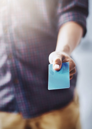 He always pays on time. an unrecognizable man holding his card out to make payment.