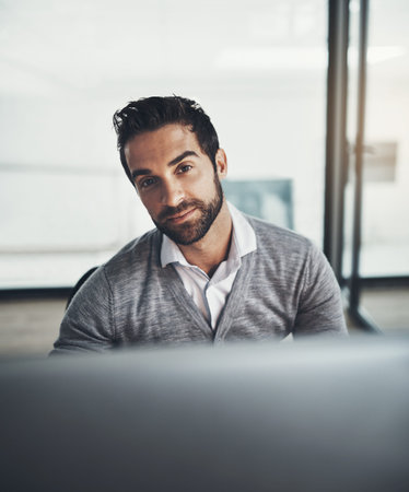 Work hard and leave nothing to chance. Portrait of a young businessman working on a computer in an...