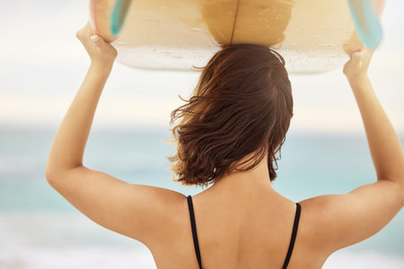 Surfing, beach and woman with a surfboard on her head while on a summer vacation in Hawaii. Travel,...