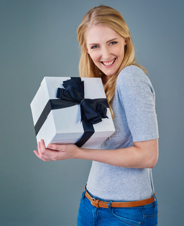 For me You shouldnt have. Cropped studio shot of a happy young woman receiving a present.の写真素材