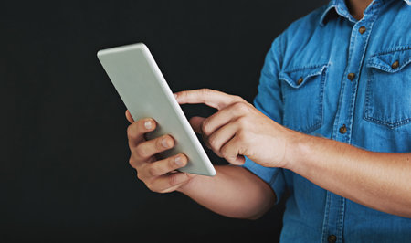 Mixing technology with success. Studio shot of a young man using a digital tablet.