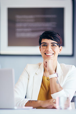Totally content with my career. Portrait of a young businesswoman working at her desk.の写真素材