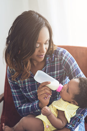 Making sure she never goes hungry. a young mother feeding her baby girl at home.の写真素材