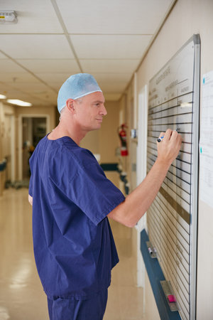 Updating the weekly rotations. a male doctor writing on a whiteboard in the hospital.