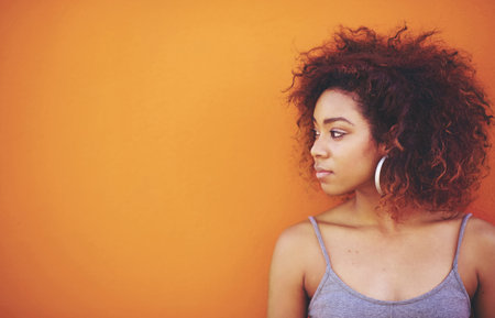 I could rule the world with these curls. an attractive young woman posing against a colorful background.の写真素材