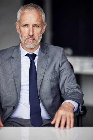 Ive worked hard to get ahead of the pack. Cropped portrait of a mature businessman sitting in his...