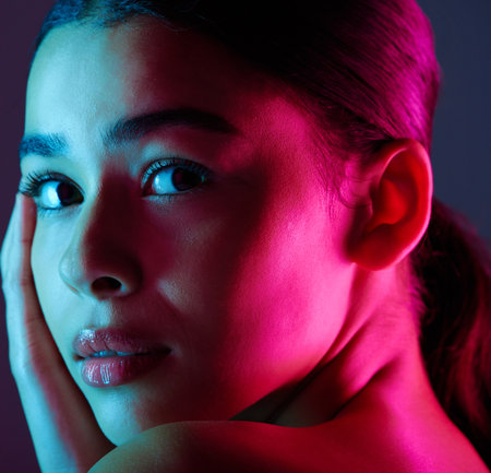 Beauty, neon shadow light and portrait of woman with dark lighting, facial cosmetics and skincare glow. Luxury studio makeup, aesthetic creativity and face model with creative pink blue color designの写真素材