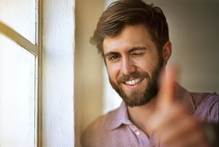 Do it with passion or not at all. Cropped portrait of a businessman giving the thumbs up while standing by his office window.の写真素材