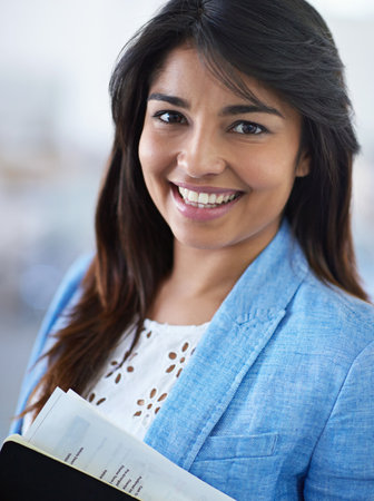 Thriving in a creative environment. Cropped portrait of a young businesswoman in the office corridor.の写真素材