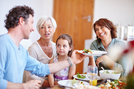 Served with love. a multi-generational family having a meal together.の写真素材