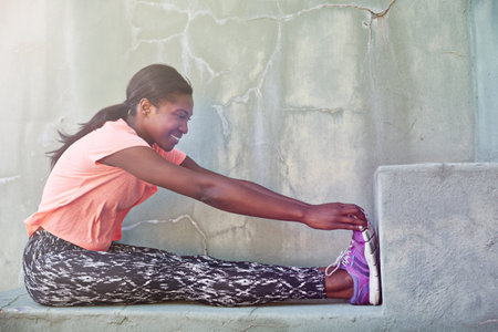 Stretch your limits and go beyond them. Full length shot of an attractive young woman stretching outdoors.の写真素材