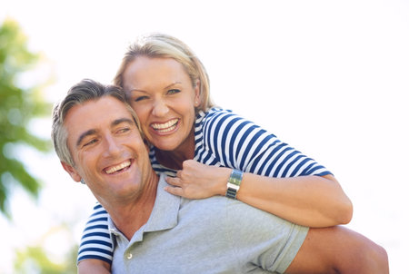 Taking time out for some loving. Cropped portrait of an attractive mature woman on her husbands back...