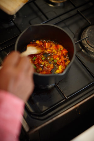 Mouthwatering meal. a man cooking a mixture of chopped vegetables on the stove.