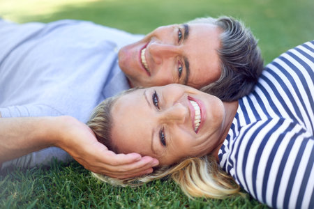 What a perfect day at the park. Cropped portrait of an affectionate mature couple lying in the park.の写真素材