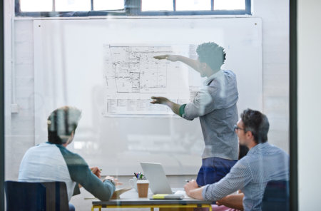 His vision is unique. a group of architects discussing plans.の写真素材