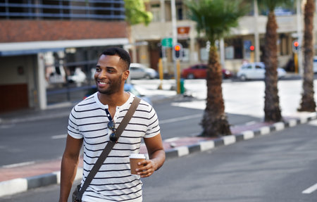 Urban style on the move. A handsome african american businessman out in the city while on his way to work.の写真素材