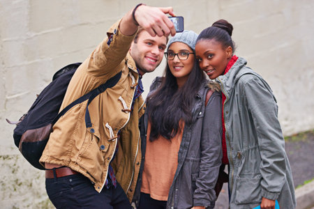Student life snapshots. a group of college students taking a selfie on campus.
