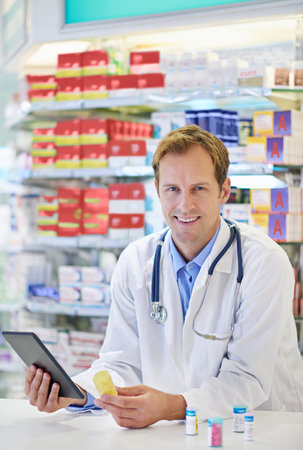 Good health starts here...A pharmacist working on a digital tablet.の写真素材