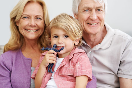 He reminds us of the good old days. a senior couple sitting with their adorable grandson.