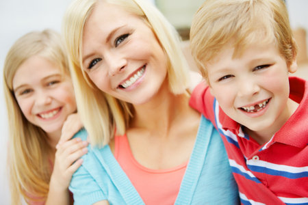 Shes so proud of her kids. Happy young family sitting together outdoors.の写真素材