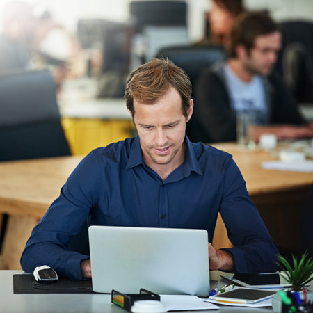 Hes always focused when hes working. a handsome mature businessman working on his laptop in the...